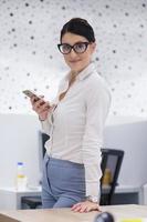 Elegant Woman Using Mobile Phone in startup office building photo