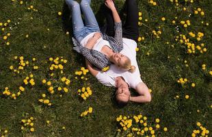 man and woman lying on the grass photo