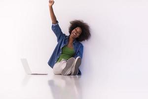 african american woman sitting on floor with laptop photo