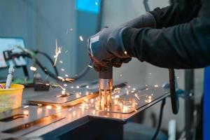a woman working in the modern metal production and processing industry welds the product and prepares it for a cnc machine photo