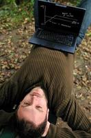 joven empresario trabajando en una laptop al aire libre foto