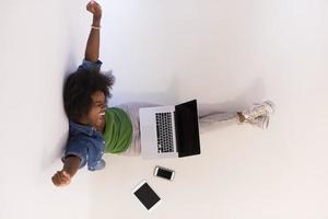 mujer afroamericana sentada en el suelo con vista superior del portátil foto