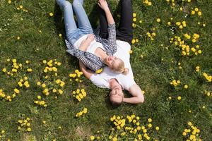 man and woman lying on the grass photo