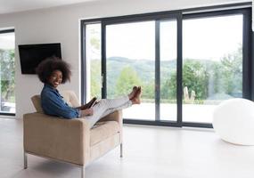 mujer afroamericana en casa con tableta digital foto