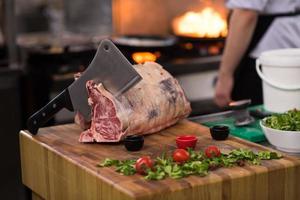 chef cutting big piece of beef photo