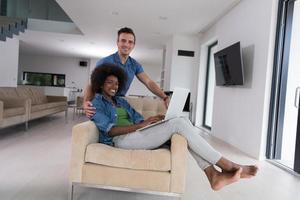 multiethnic couple on an armchair with a laptop photo