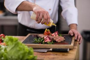 Chef finishing steak meat plate photo