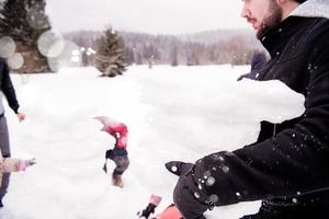 grupo de jóvenes haciendo un muñeco de nieve foto