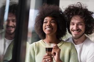 feliz pareja multiétnica relajándose en casa moderna en el interior foto