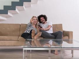 Young couple on the sofa watching television photo