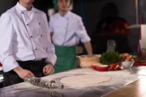 chef preparing dough for pizza photo