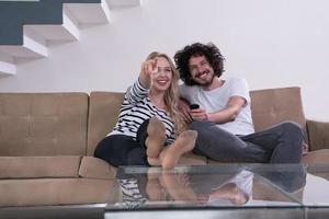 Young couple on the sofa watching television photo