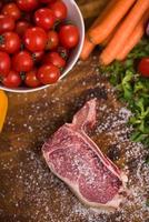 top view of raw steak on wooden table photo