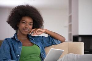 african american woman at home with digital tablet photo