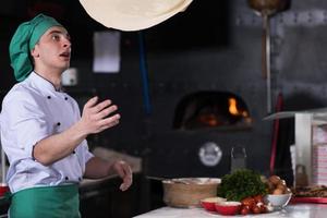 chef throwing up pizza dough photo