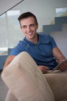 young man using a tablet at home photo