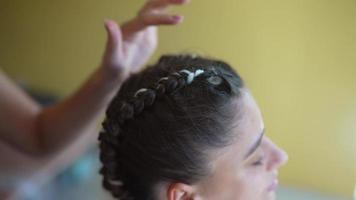 Girls braiding hair with a white strand of hair video