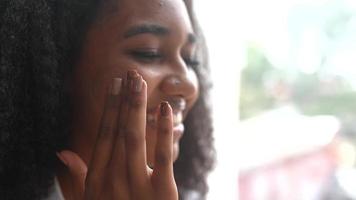 mooi zwart vrouw shows haar huidsverzorging routine- video