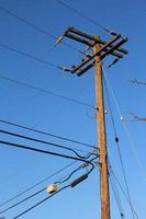 postes eléctricos de madera contra un cielo azul oscuro. En América foto