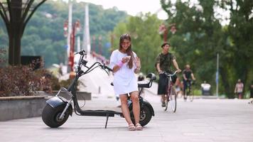 une jeune femme fait du scooter électrique par une journée ensoleillée video