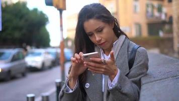 femme occupée dans la rue avec smarthphone video