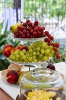 glass fruit basket, Picninc outside. out of focus vegetation in the background. photo