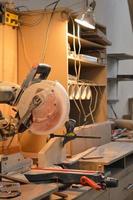 A man cuts wood on a circular saw in a joinery, band saw, holding a plank photo