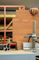 A man cuts wood on a circular saw in a joinery, band saw, holding a plank photo