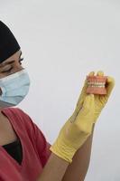 The woman dentist is holding dentures in his hands and instruments photo