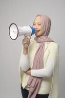 Young beautiful woman holding megaphone over white background studio. photo