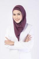 Beautiful muslim business woman wearing white suit with hijab in studio photo