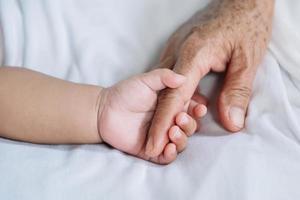 Close up baby hand on mother's hands photo