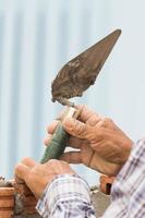 Bricklayer working in construction site of a brick wall photo