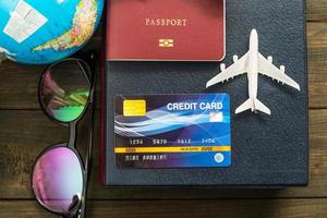 Credit card and airplane model on wooden table photo