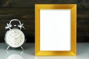 Mockup with golden frame and alarm clock photo
