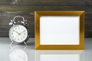 Picture mock up with golden frame and alarm clock