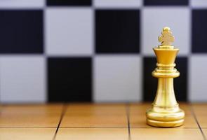 Gold king chess piece on wood chessboard photo