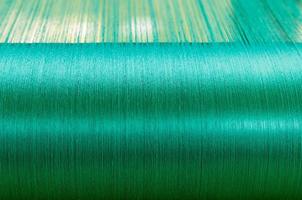 Green silk on a warping loom of a textile mill photo