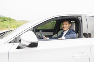 Businessman holding modern car keys, alarm system and steering wheel with electric buttons - male hand holding keys photo