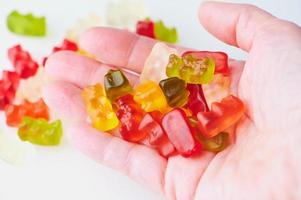 lot of gummy bears in a woman hand photo