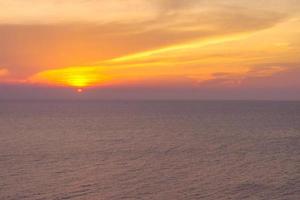 hermosa puesta de sol sobre la playa del mar, con nubes en el cielo crepuscular fondo de hermosos colores. foto