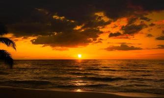 hermosa puesta de sol sobre el mar en el fondo del cielo naranja de la playa tropical para viajes y vacaciones foto