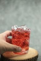 Refresco de agua roja con gas con cubitos de hielo. bebida helada de verano foto