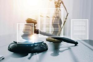 Justice and law concept.Male judge in a courtroom with the gavel, working with, computer and docking keyboard, eyeglasses, on table in morning light photo