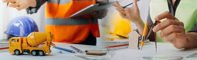 Two colleagues discussing data working and tablet, laptop with on on architectural project at construction site at desk in office photo