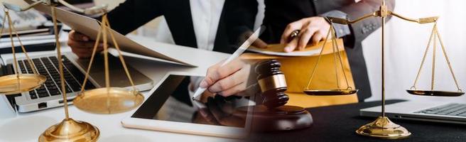 Business and lawyers discussing contract papers with brass scale on desk in office. Law, legal services, advice, justice and law concept picture with film grain effect photo