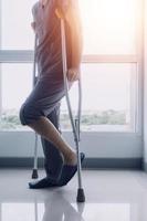 young asian physical therapist working with senior woman on walking with a walker photo