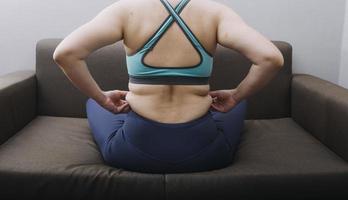 Beautiful fat woman with tape measure She uses her hand to squeeze the excess fat that is isolated on a white background. She wants to lose weight, the concept of surgery and break down fat under the photo