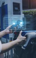 Hand plugging in a charger in an electric car socket.Electric car or ev is charging at station photo