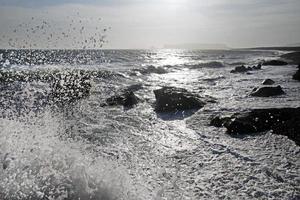 olas que llegan a reynisfjara black beach, islandia, con formaciones rocosas en el fondo foto